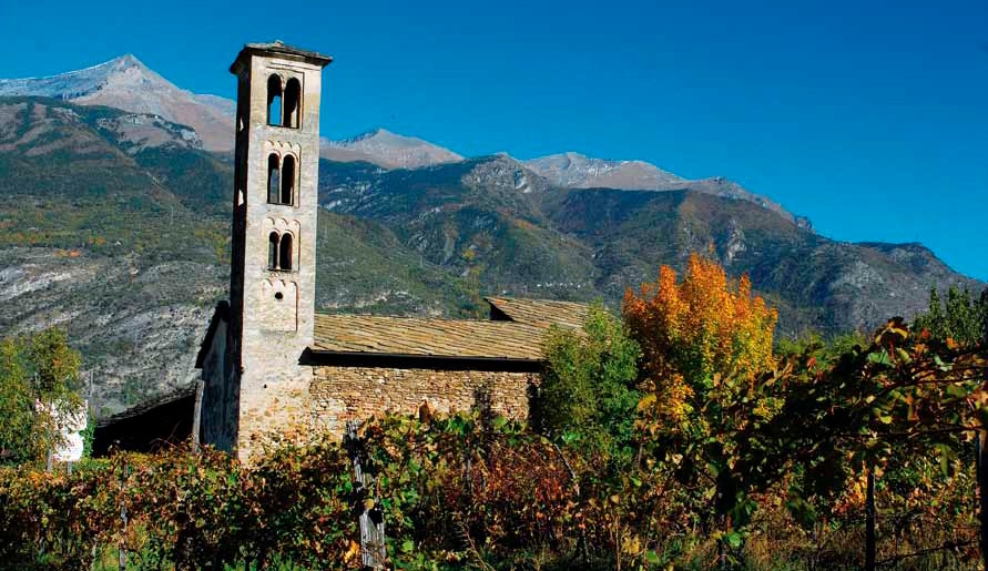 vista laterale della Chiesa. Molto evidente il campanile e la vegetazione di sfondo. 