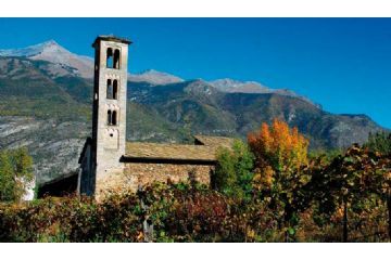vista laterale della Chiesa. Molto evidente il campanile e la vegetazione di sfondo. 